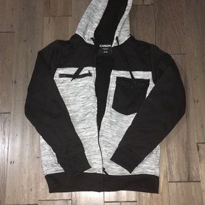 A zip up jacket with a hoodie.